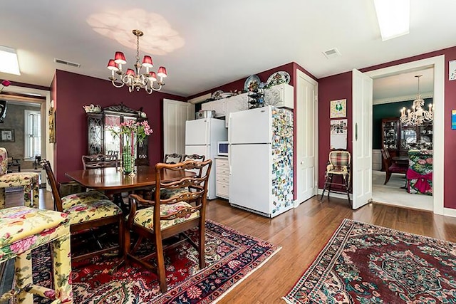 dining space featuring an inviting chandelier and hardwood / wood-style flooring