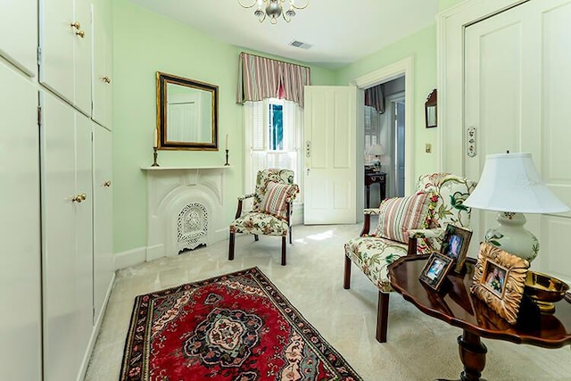 sitting room with light carpet and a notable chandelier