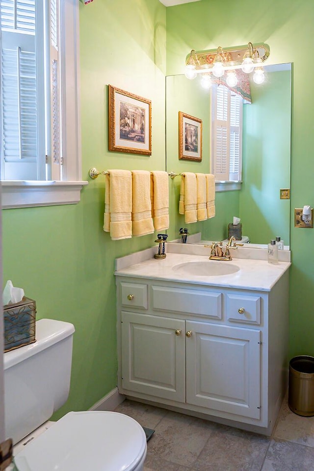 bathroom with tile floors, toilet, and vanity