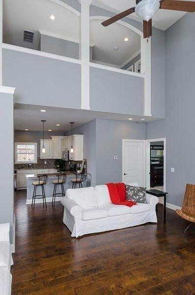 living room featuring a towering ceiling, ceiling fan, and dark hardwood / wood-style flooring