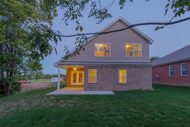 back of property with a yard and a patio area