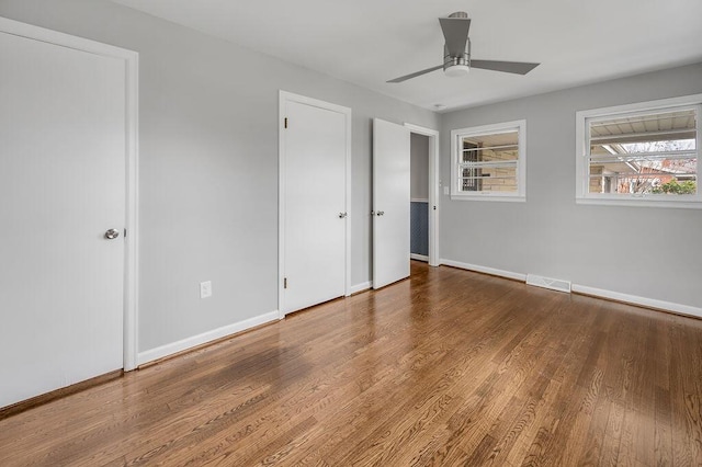 unfurnished bedroom featuring ceiling fan and dark hardwood / wood-style floors