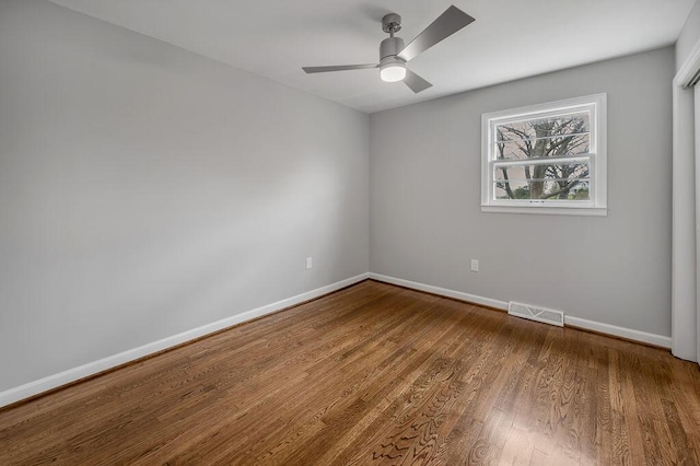 empty room with dark hardwood / wood-style flooring and ceiling fan