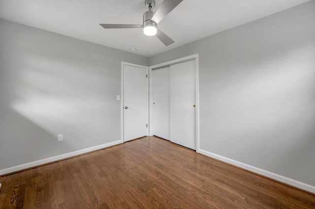 unfurnished bedroom with ceiling fan, a closet, and dark hardwood / wood-style flooring