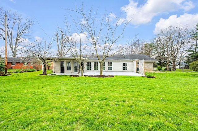 back of house with a lawn and a patio