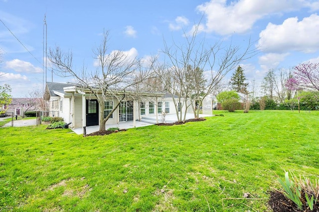 back of property with a yard and a patio