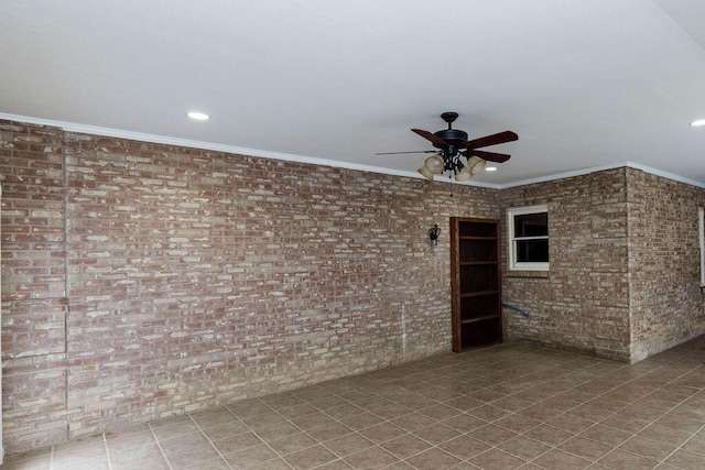 tiled spare room featuring ceiling fan, crown molding, and brick wall