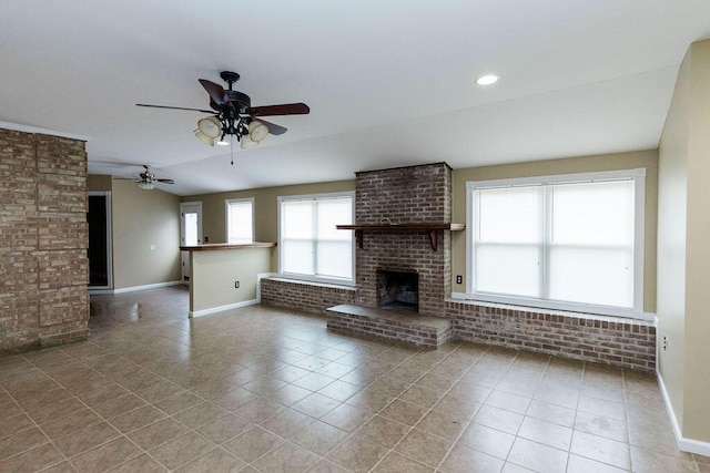 unfurnished living room with brick wall, a brick fireplace, tile floors, and ceiling fan