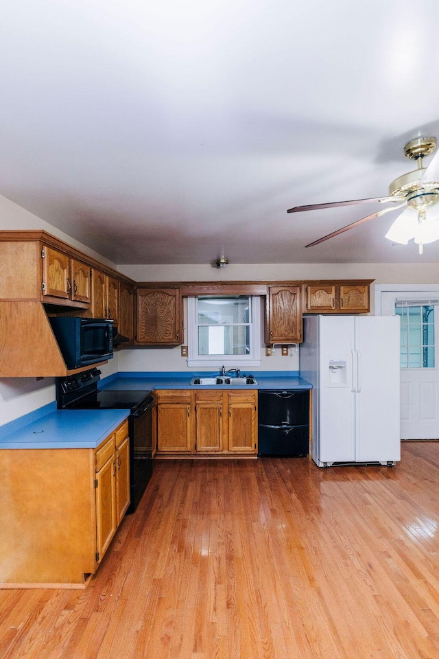 kitchen featuring ceiling fan, black appliances, and light hardwood / wood-style flooring