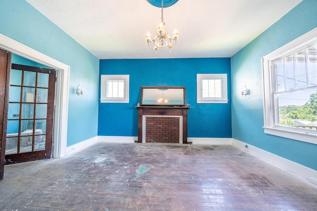 unfurnished living room with a chandelier and a textured ceiling