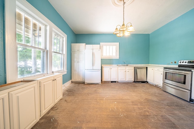 kitchen with sink, hanging light fixtures, light hardwood / wood-style floors, stainless steel appliances, and a notable chandelier