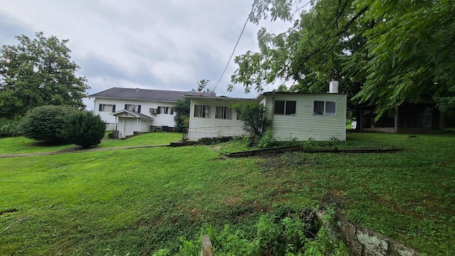 rear view of property featuring a yard