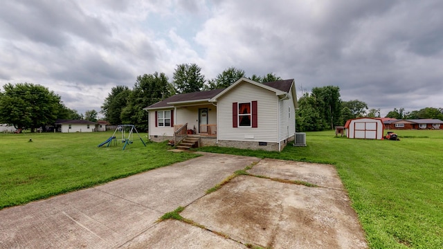 view of front of house featuring a front yard and a storage shed