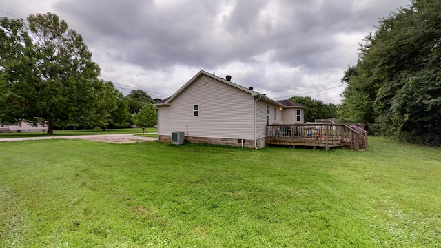 exterior space featuring a deck, central air condition unit, and a yard