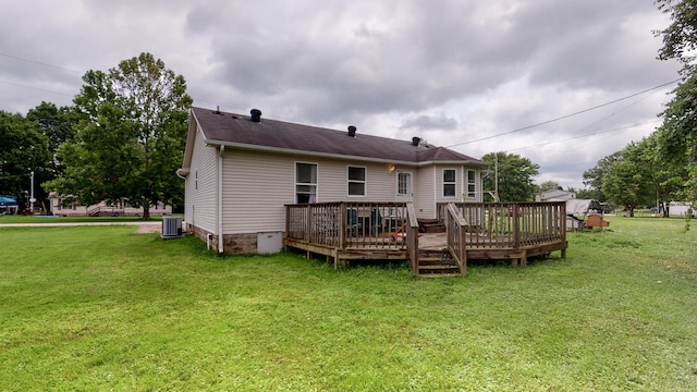 rear view of house featuring a lawn, central air condition unit, and a wooden deck