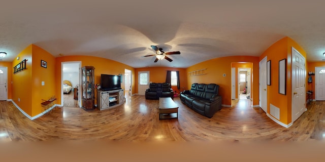 living room featuring ceiling fan and hardwood / wood-style flooring