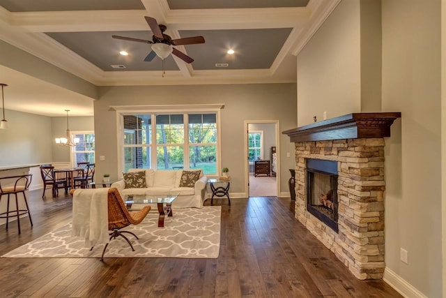 living room featuring crown molding, dark hardwood / wood-style flooring, ceiling fan with notable chandelier, and a fireplace