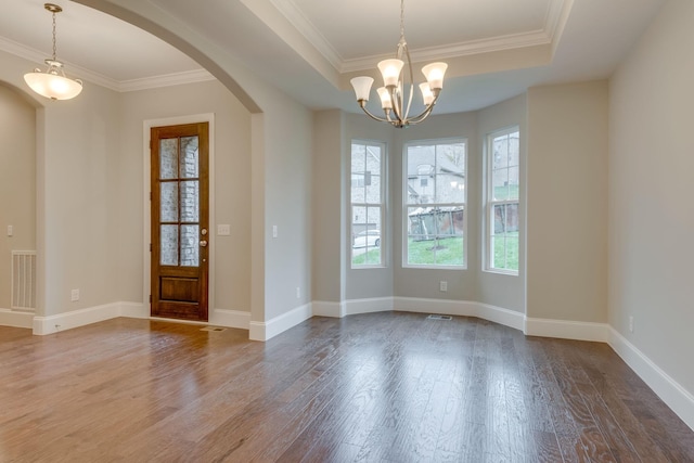 unfurnished room featuring crown molding, a tray ceiling, hardwood / wood-style flooring, and an inviting chandelier