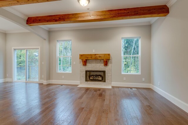 unfurnished living room with ornamental molding, beam ceiling, and light hardwood / wood-style flooring