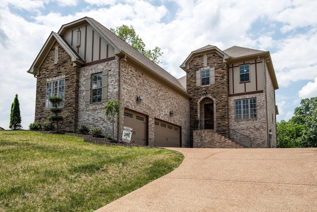 tudor house featuring a front yard and a garage