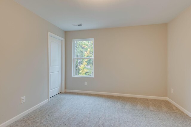 spare room featuring light carpet