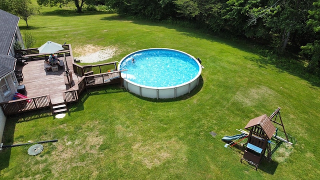 view of swimming pool with a lawn and a wooden deck