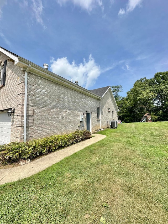 view of side of property featuring a garage and a lawn