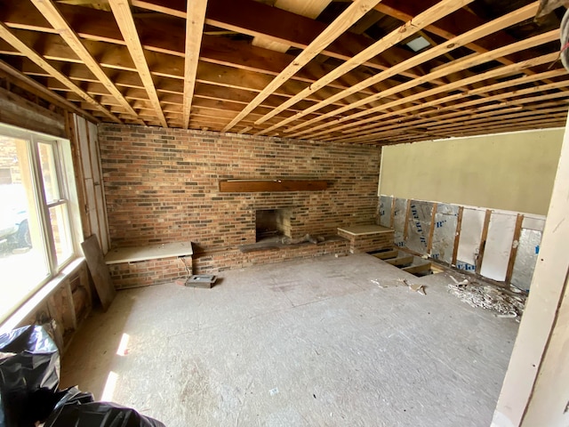 basement with brick wall and a brick fireplace