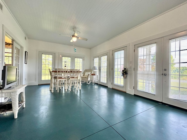 unfurnished sunroom featuring ceiling fan, french doors, and a healthy amount of sunlight