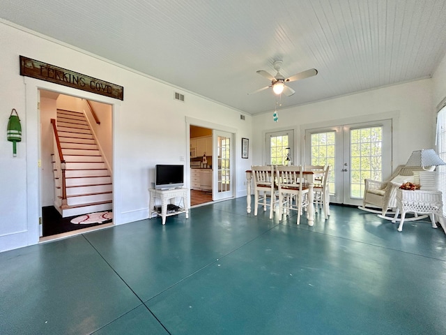 unfurnished living room with ceiling fan, crown molding, and french doors