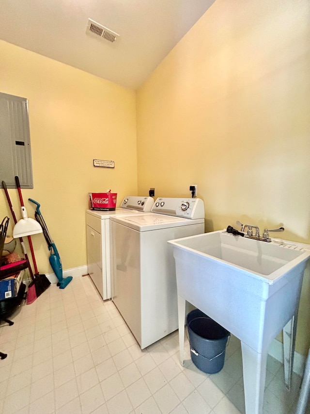 clothes washing area featuring washer and clothes dryer, sink, and light tile floors