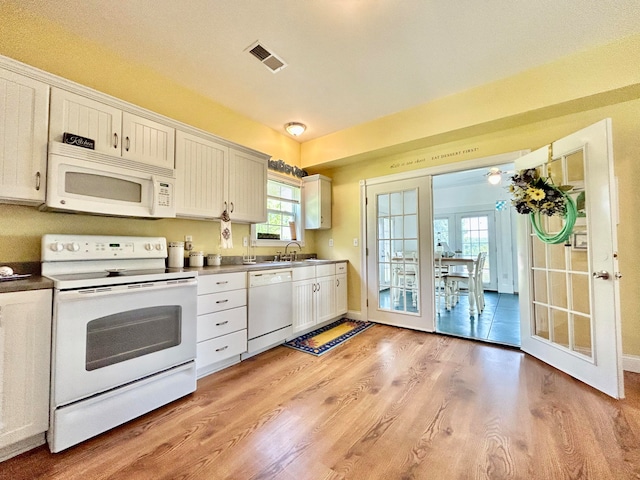 kitchen featuring white cabinets, french doors, white appliances, and light wood-type flooring