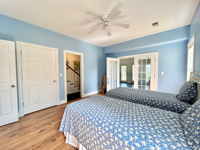 bedroom featuring ceiling fan, light wood-type flooring, and french doors