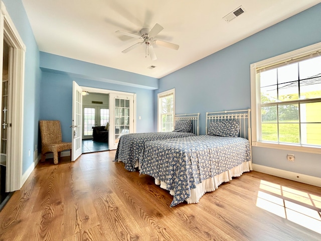 bedroom featuring ceiling fan, light hardwood / wood-style floors, and french doors