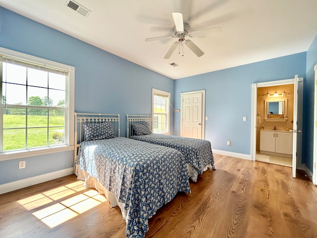 bedroom with ensuite bath, ceiling fan, and light wood-type flooring