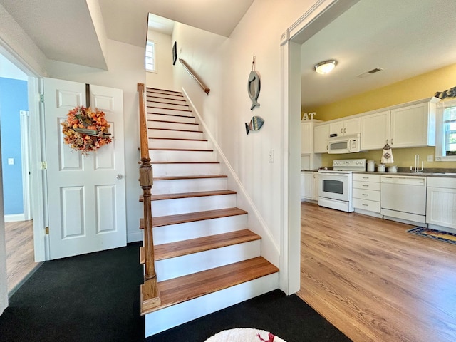 staircase featuring light hardwood / wood-style floors