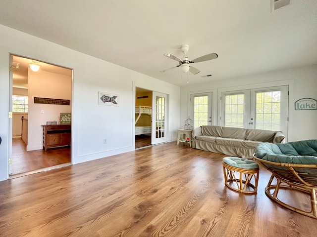 living room with french doors, hardwood / wood-style floors, and ceiling fan