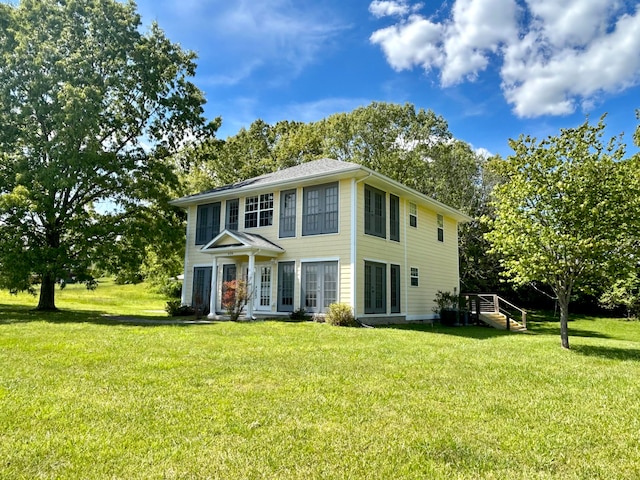 rear view of property with a lawn