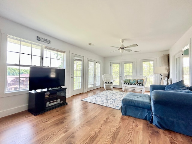 living room featuring ceiling fan, light hardwood / wood-style floors, and french doors