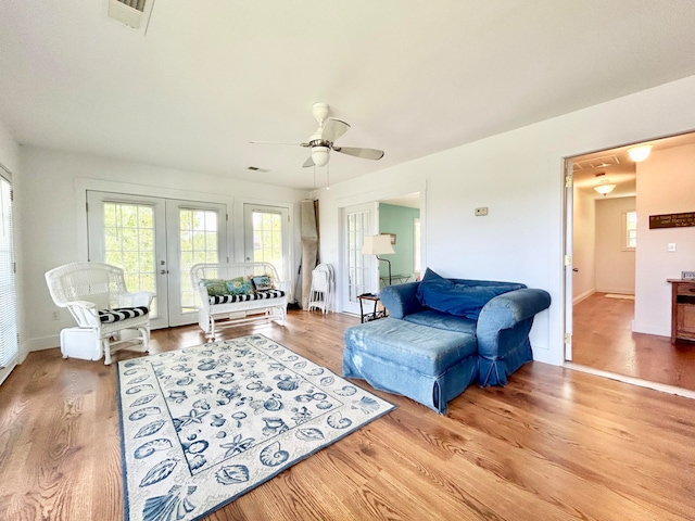 living room with ceiling fan, light hardwood / wood-style flooring, and french doors