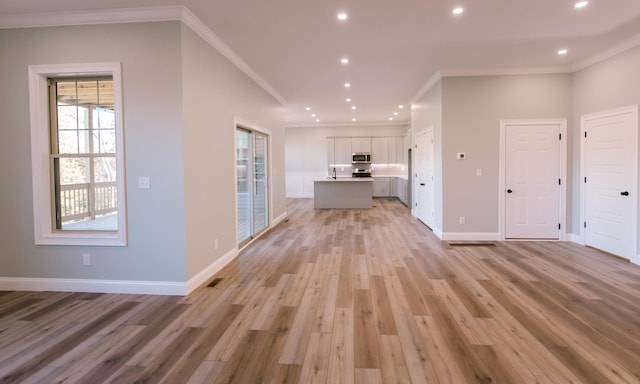 corridor with light hardwood / wood-style flooring and ornamental molding