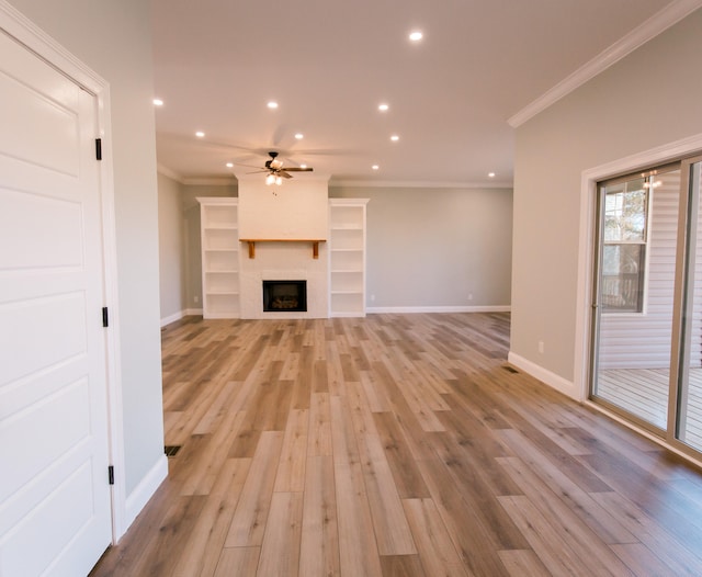 unfurnished living room with ceiling fan, ornamental molding, a fireplace, and light hardwood / wood-style floors