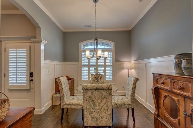 dining space with crown molding, dark hardwood / wood-style floors, and a chandelier