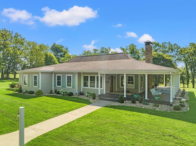 view of front of house with a porch, a front yard, roof with shingles, and a chimney