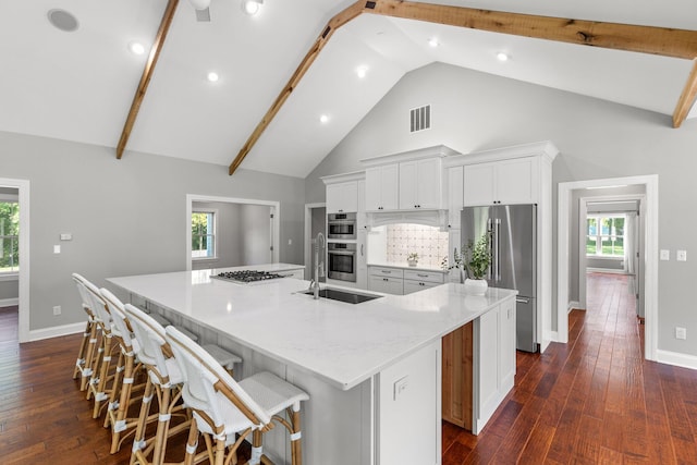 kitchen with visible vents, a large island, appliances with stainless steel finishes, white cabinets, and dark wood-style flooring