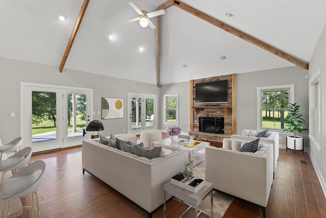 living area featuring beam ceiling, a fireplace, and wood-type flooring