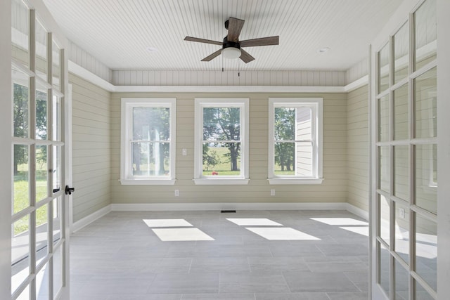 unfurnished sunroom with french doors, visible vents, and ceiling fan