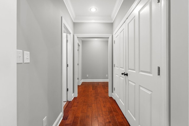 hall with dark wood-style floors, baseboards, and ornamental molding