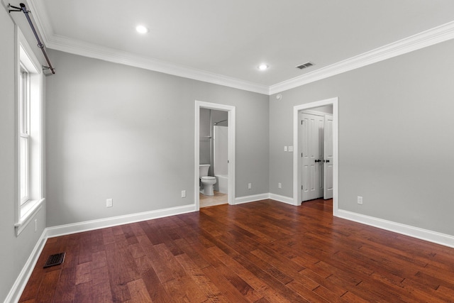 empty room with visible vents, baseboards, wood finished floors, and ornamental molding