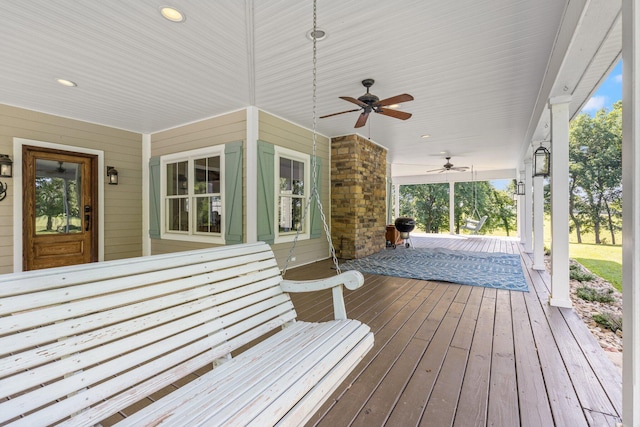 wooden terrace with covered porch and ceiling fan